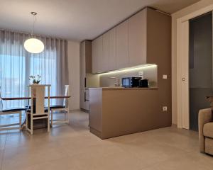 a kitchen and living room with a table and chairs at La Vela Luxury Apartment in Pescara +16 photos