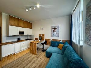 a living room with a blue couch and a kitchen at Like-a House Centrum in Płock
