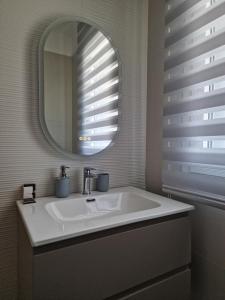 a bathroom with a sink and a mirror at La Vela Luxury Apartment in Pescara