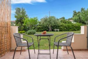 two chairs and a table with a bowl of fruit on a patio at Julia Hotel in Fourka