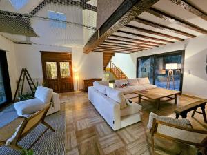 a living room with white couches and a table at Ker Ty Mor - Waterfront Family House in Port-Louis