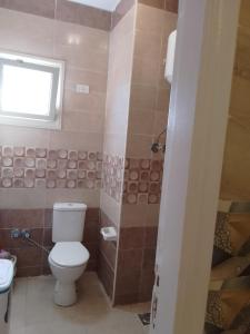 ein Bad mit einem WC und einem Fenster in der Unterkunft مستقبل للشقق الفندقيه والالعاب المائيه in El-Alamein