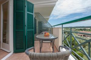 a patio with a table and chairs on a balcony at Julia Hotel in Fourka