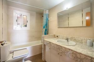 a bathroom with a sink and a toilet and a tub at Imperatore Apartment in Cunit +15 photos
