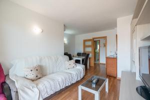 a living room with a white couch and a table at Imperatore Apartment in Cunit