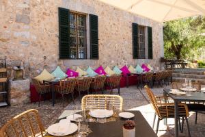 a restaurant with tables and chairs and a stone wall at Ca's Xorc Luxury Retreat - ADULTS ONLY in Sóller