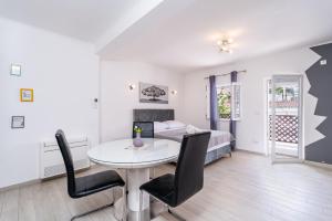 una habitación con una mesa y sillas y una cama en Studio Apartment Feather, en Dubrovnik