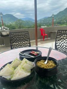 Una mesa con dos platos de comida y un tazón de frijoles. en The Blossom Glee, en Bhimtal