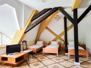 a living room with wooden beams and a tv at Pałac Bogaczów - noclegi - restauracja - przyjęcia in Bogaczów