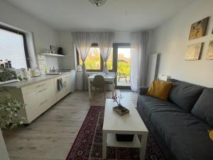 a living room with a couch and a table at Stilvolles Apartment nahe Therme und PreZero Arena in Sinsheim