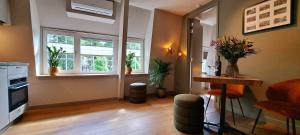 a living room with two windows and a table with plants at Gasterij 't Hilletje in Kootwijk