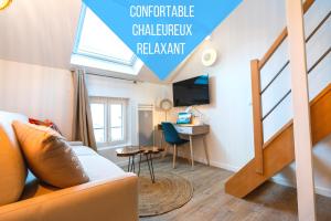ein Wohnzimmer mit einer Couch und einem Schreibtisch in einem Zimmer in der Unterkunft Self Checkin Automatique - Centre-ville - OCÉANIE in La Ferté-sous-Jouarre