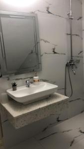 a bathroom with a sink and a mirror at Oriente Sole in Dhërmi +14 photos
