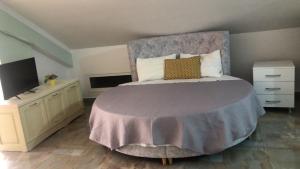 a bedroom with a large bed and a tv at Oriente Sole in Dhërmi