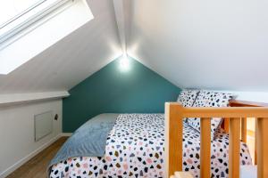 ein Schlafzimmer mit einem Bett auf dem Dachboden in der Unterkunft Self Checkin Automatique - Centre-ville - OCÉANIE in La Ferté-sous-Jouarre + 11 Fotos
