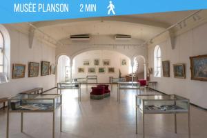 ein Museum mit Glastischen in einem Raum mit Gemälden in der Unterkunft Self Checkin Automatique - Centre-ville - OCÉANIE in La Ferté-sous-Jouarre