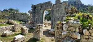 an old stone building with a doorway in a field at Bayrams Tree Houses in Olympos