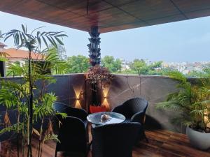a balcony with a table and chairs and plants at Triton Suites By Bestinn Leisure in Bengaluru