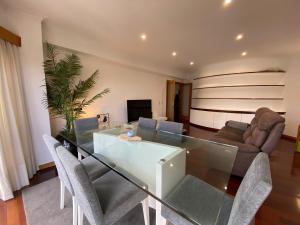 a dining room with a glass table and chairs at Tertúlias com as ondas, T2 in Vila do Conde