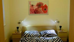 a bedroom with a bed with zebra pillows and two lamps at Apartments Světluška in Loučná nad Desnou