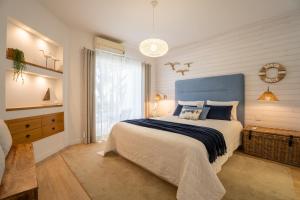 a bedroom with a large bed with a blue headboard at Luxury Beach House Apartment - Golf & Tennis Court & Pool View in Albufeira +34 photos