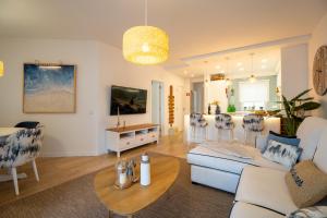 a living room with a couch and a table at Luxury Beach House Apartment - Golf & Tennis Court & Pool View in Albufeira