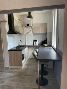 una piccola cucina con un bancone nero e un tavolo di Studio du Vercors a Fontaine