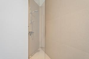 una ducha con puerta de cristal en un baño en Luxueus en smaakvol prive appartement Sint-Idesbald, en Koksijde
