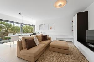 Una sala de estar con un sofá y un televisor. en Luxueus en smaakvol prive appartement Sint-Idesbald, en Koksijde