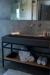 a bathroom with a sink and towels on a shelf at Doria Luxury Boutique Hotel in Dishon
