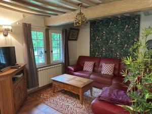 a living room with a couch and a coffee table at petite chaumière in Tourville-sur-Pont-Audemer