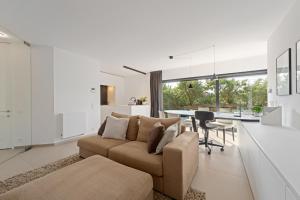 una sala de estar con un sofá y una mesa en Luxueus en smaakvol prive appartement Sint-Idesbald, en Koksijde