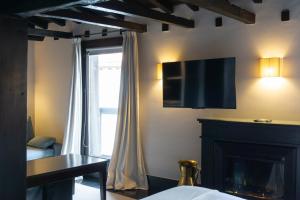 a room with a fireplace and a television on the wall at La Plaza in Hervás