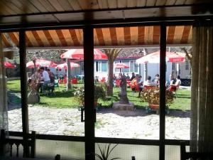 una ventana con vistas a un parque con mesas y sombrillas en Hotel Rural el Arco, en Pesquera de Ebro