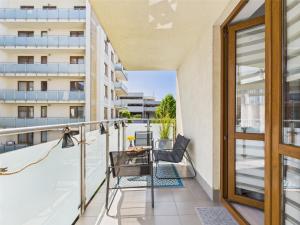een balkon met een tafel en stoelen op een gebouw bij ApartamentySnu, Słoneczny Glam z parkingiem, Centrum in Radom