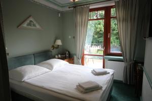 ein Schlafzimmer mit einem Bett mit zwei Handtüchern darauf in der Unterkunft Willa Amor in Krynica Morska