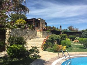 a house with a stone wall and a swimming pool at Ada Bacchus Hotel in Bozcaada