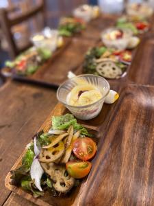 a long wooden table topped with different types of food at SUNAORetreat奥白浜 in Minamiboso +33 photos