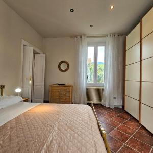 a bedroom with a large bed and a window at Il Girasole Holiday Home in Porto Ceresio