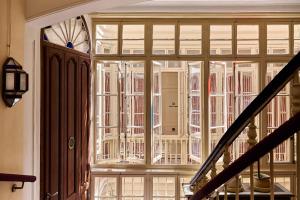 a large glass window in a room with a staircase at Cristine Bedfor Malaga Boutique Hotel in Málaga