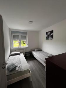 多姆扎莱Larisa apartma的有两张床和一扇窗户的卧室