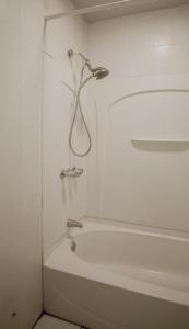 a white bathroom with a bath tub and a shower at Private room with Shared bath on Union Square 11 in New York