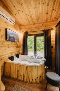 a large wooden bathroom with a tub and a window at Lavender Tiny House in Çamlıhemşin +26 photos