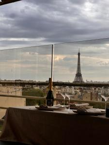 a table with two wine glasses and the eiffel tower at Luxury Flat With Terrace & Eiffel Tower View in Paris