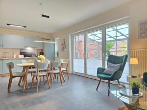 a kitchen and living room with a table and chairs at Ferienhaus Golfkate Eagle in Hage +36 photos