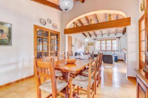 a dining room with a wooden table and chairs at Villa Can March by Villa Plus in Cala de Sant Vicenc