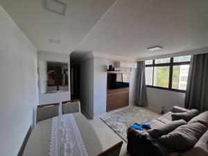 a white living room with a couch and a window at Asa Norte - Suíte Premium - Conforto e praticidade in Brasília