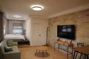 un soggiorno con un divano e una TV di Casa Cohen Hashaked Kinneret קאסה כהן השקד כנרת a Migdal