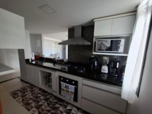 a kitchen with a black counter top and a microwave at Asa Norte - Suíte Premium - Conforto e praticidade in Brasília