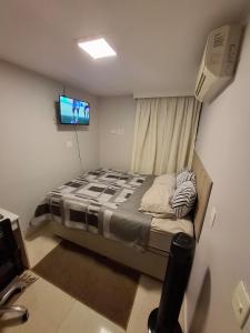 a small bedroom with a bed and a television at Asa Norte - Suíte Premium - Conforto e praticidade in Brasília
